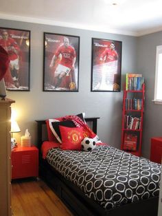 a bedroom decorated in red and black with pictures on the wall