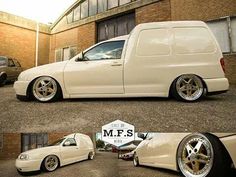 a white car parked in front of a brick building next to another vehicle with chrome rims