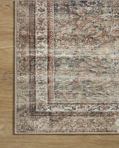 an area rug on a wooden floor with a wood floor in the foreground and a light brown background