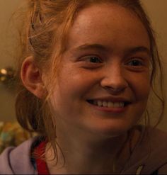 a close up of a person smiling and holding a toothbrush in one hand with the other