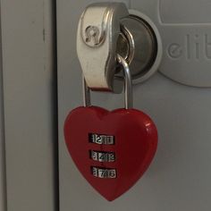 a red heart shaped padlock attached to a door