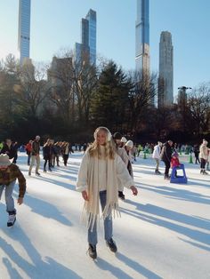 people skating on an ice rink with skyscrapers in the backgroung area