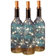 three bottles with lights in them sitting next to each other