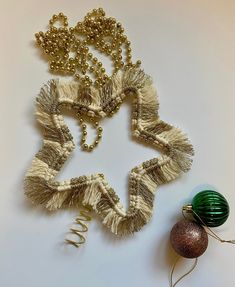 an ornament and some ornaments on a white table with a green bauble