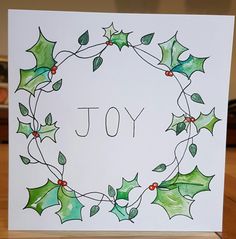 a christmas card with holly leaves and the word joy written on it in cursive writing