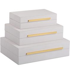 three white boxes with gold handles stacked on top of each other