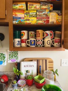 the kitchen counter is full of coffee mugs and other items that are stacked on top of each other