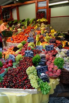 an open market with lots of fresh fruits and veggies on display for sale