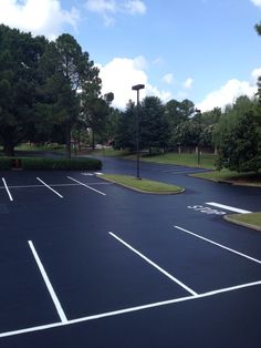 an empty parking lot surrounded by trees and bushes