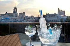 two wine glasses sitting on top of a table next to a bottle and glass filled with water