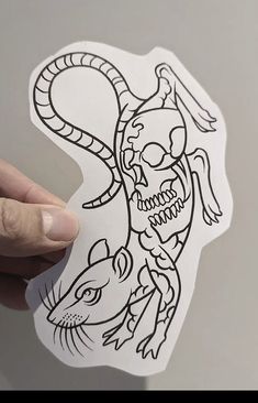 a person holding up a sticker with a drawing on it