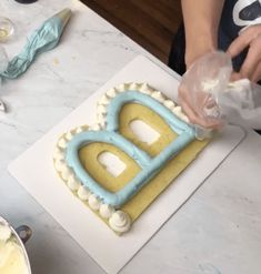 a person is decorating a cake with icing