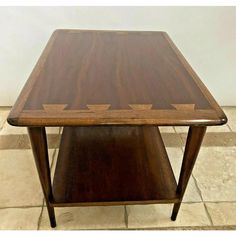 a wooden table sitting on top of a tiled floor