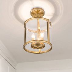 a light that is hanging from the ceiling in a room with white walls and flooring