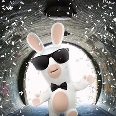 a rabbit wearing sunglasses and bow tie standing in front of a tunnel filled with confetti