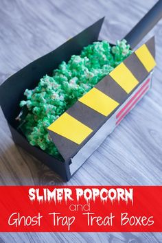 a box filled with green and yellow popcorn sitting on top of a wooden table next to a