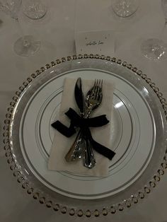 a place setting with silverware and black ribbon