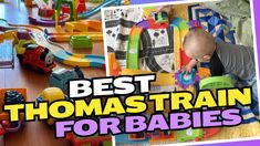 there is a baby playing with toys on the floor and in front of it are pictures of thomas train tracks