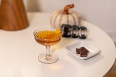 a small glass filled with liquid sitting on top of a white table