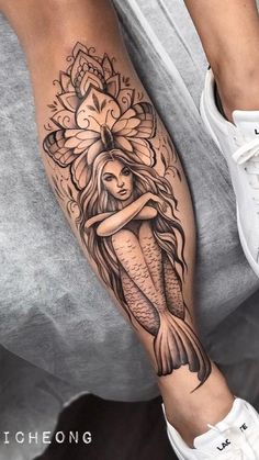 a woman's leg with a tattoo on it and a mermaid holding a flower