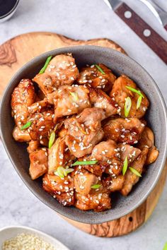 a bowl filled with chicken and sesame seeds