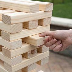 a person is holding a wooden block tower