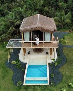 an aerial view of a house with a thatched roof and pool in the yard