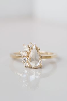 an engagement ring with a pear shaped diamond and two smaller pears on the side