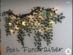 there is a wall decoration with vines and lights on the side of it, which reads poo funderaiser