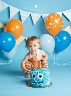 a baby sitting on top of a blue cake