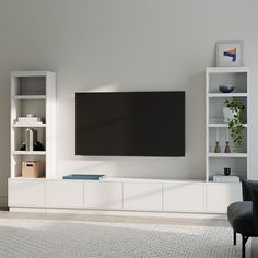 a large flat screen tv mounted to the side of a white wall in a living room