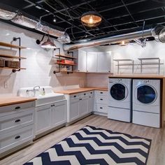 a laundry room with washer, dryer and cabinets in the middle of it