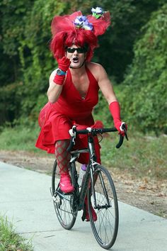 a woman dressed in red riding a bike