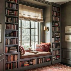 a room filled with lots of books on top of a book shelf next to a window