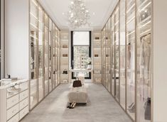 a walk - in closet with lots of white furniture and chandelier hanging from the ceiling