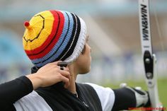 a man wearing a knitted hat while holding a cell phone up to his ear