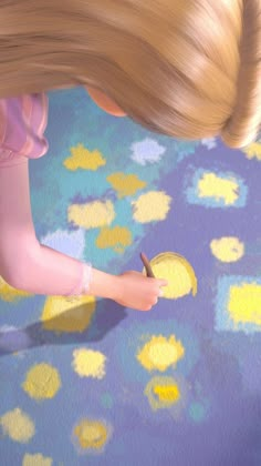 a blonde doll is holding a pencil and writing on the floor with yellow dots around it