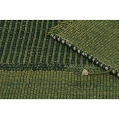 a green rug with white dots on the top and bottom, next to it is an area