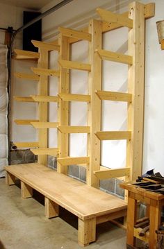 a wooden bench sitting in the middle of a room next to shelves with shoes on them