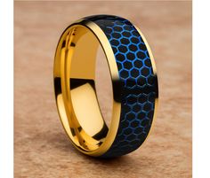 a gold and blue ring with honeycombs on the inside, sitting on a brown surface