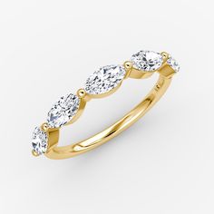 a yellow gold ring with five pear shaped diamonds on the sides and four oval stones in the middle