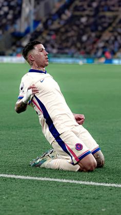 a soccer player sitting on the ground with his head in his hands and eyes closed