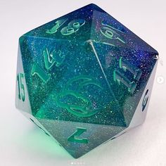 a green and blue dice sitting on top of a white table