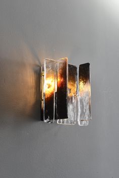 a light that is on the side of a wall with some kind of glass in it