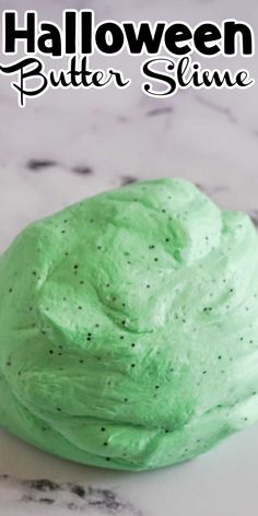 a close up of a green slime on a marble surface with the text halloween butter slime