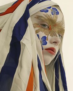 a woman with her face painted like an american flag and wearing a headdress