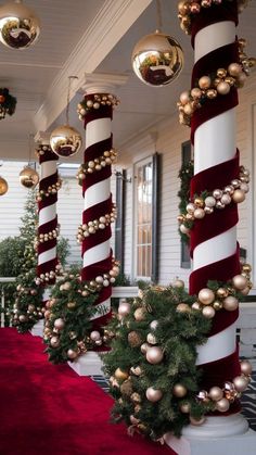 christmas decorations on the front porch of a house with red carpet and white columns decorated in gold ornaments