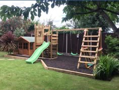 a wooden play set in the middle of a yard with a slide and climbing frame