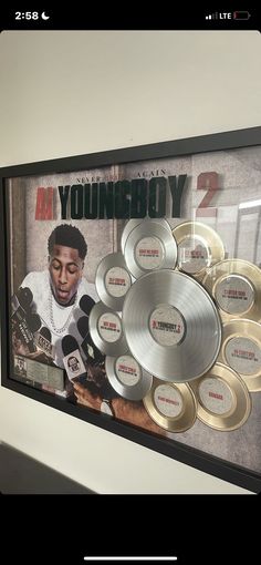 a framed photo of youngboy 2 surrounded by gold and silver discs