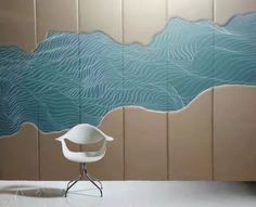 a white chair sitting on top of a table next to a wall with waves painted on it